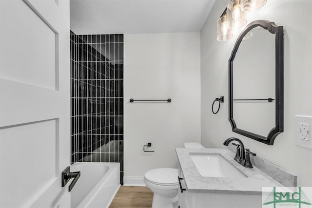 full bathroom with toilet, vanity, tiled shower / bath, and wood-type flooring