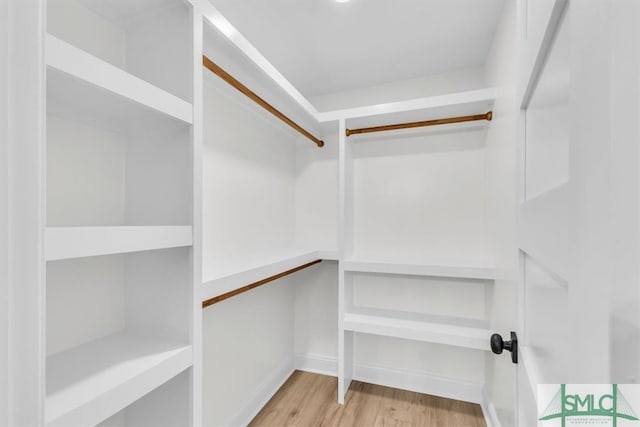 walk in closet with light hardwood / wood-style floors