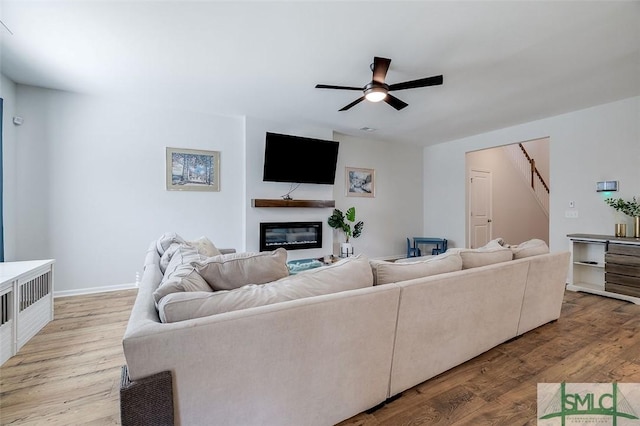 living room featuring light hardwood / wood-style flooring and ceiling fan