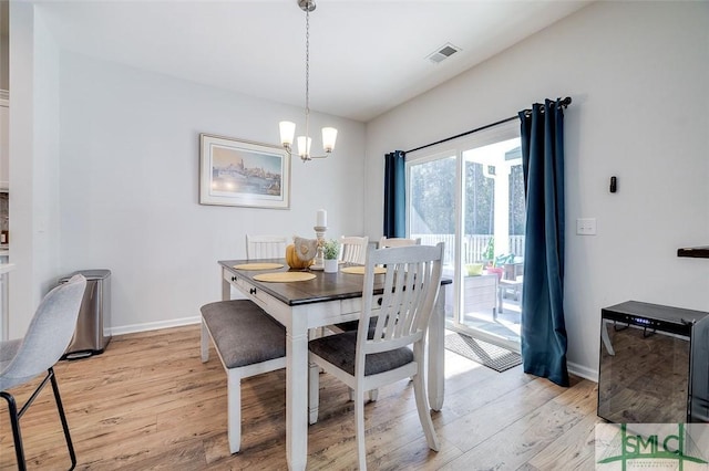 dining area with a notable chandelier and light wood-type flooring