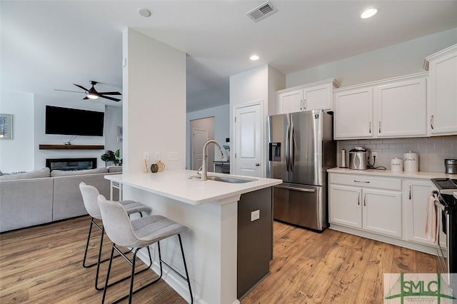 kitchen with white cabinetry, sink, a kitchen bar, and appliances with stainless steel finishes