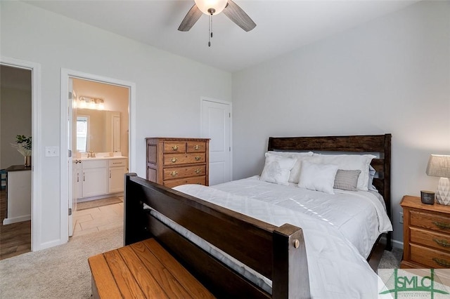 carpeted bedroom with ensuite bathroom, sink, and ceiling fan