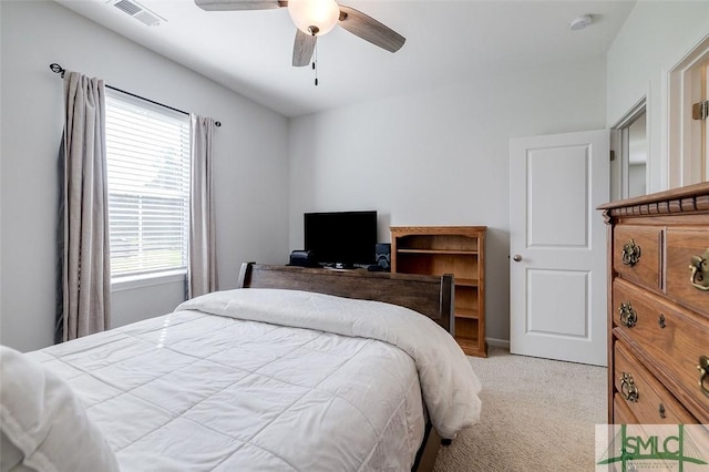 bedroom with multiple windows, ceiling fan, and light carpet