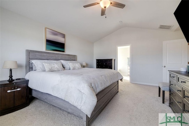 bedroom with lofted ceiling, light carpet, connected bathroom, and ceiling fan