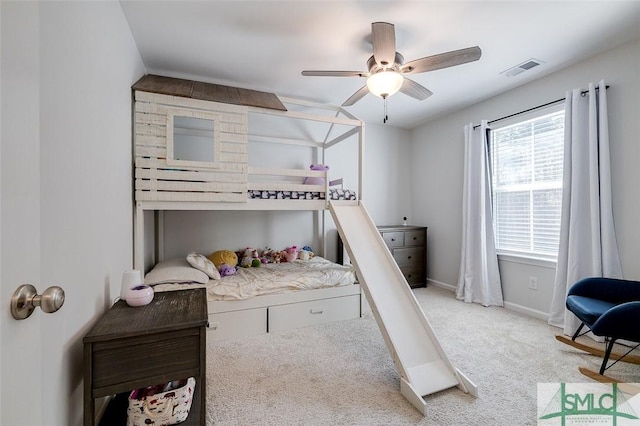 bedroom featuring multiple windows, light colored carpet, and ceiling fan