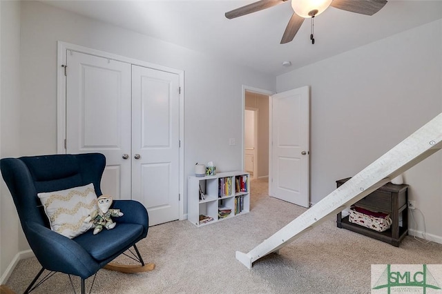 sitting room featuring light colored carpet and ceiling fan