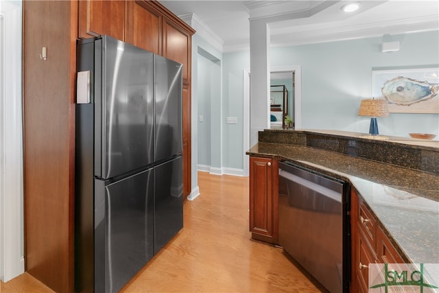 kitchen featuring dark stone countertops, light wood-type flooring, crown molding, and appliances with stainless steel finishes