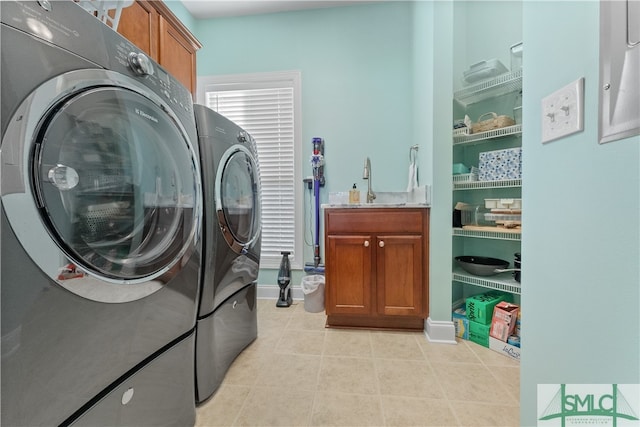 laundry room featuring cabinets, light tile patterned floors, and washer and clothes dryer