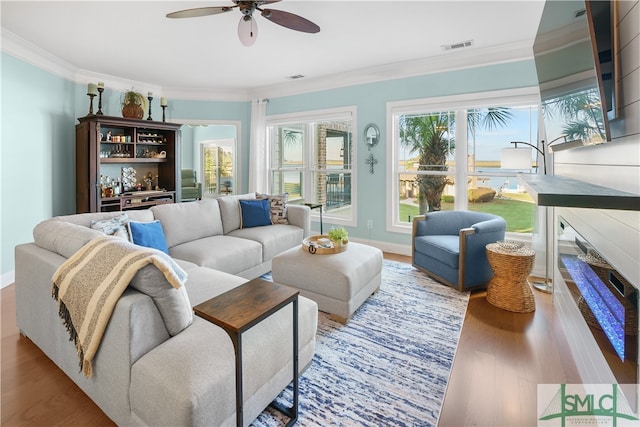 living room with crown molding, ceiling fan, and hardwood / wood-style flooring