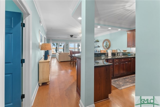 kitchen with light hardwood / wood-style flooring, ceiling fan, crown molding, and sink