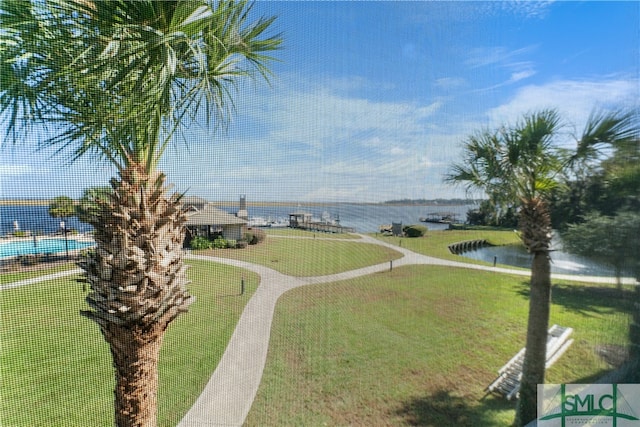 view of property's community with a lawn and a water view