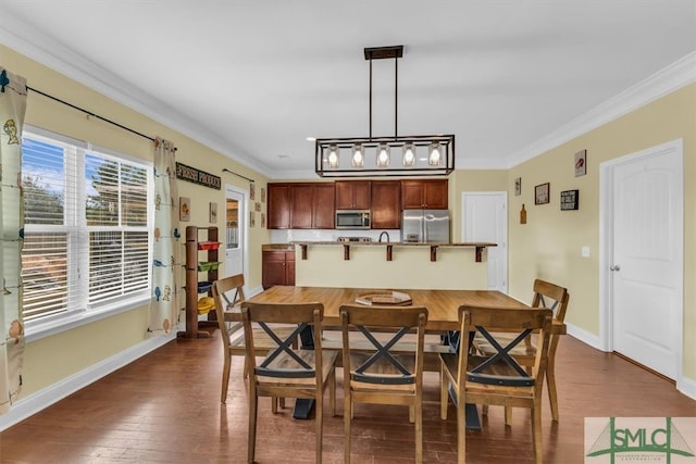 dining room with dark wood-type flooring and crown molding