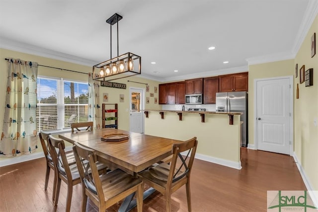 dining area with dark hardwood / wood-style floors and crown molding