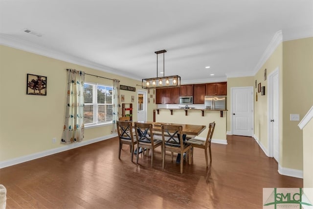 dining area featuring ornamental molding and dark hardwood / wood-style floors