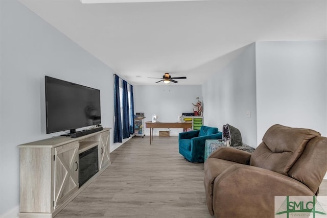 living room featuring light hardwood / wood-style floors and ceiling fan