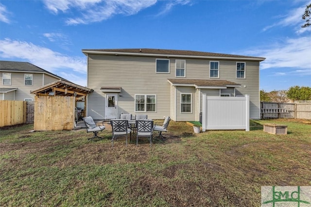 rear view of property featuring a lawn