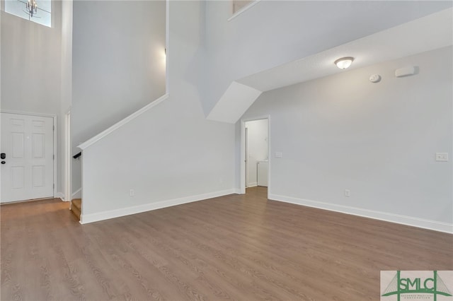 unfurnished living room featuring wood-type flooring and vaulted ceiling