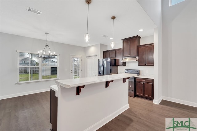 kitchen featuring a kitchen bar, refrigerator with ice dispenser, a healthy amount of sunlight, and electric stove