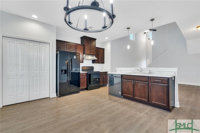 kitchen with an inviting chandelier, black appliances, sink, pendant lighting, and light hardwood / wood-style flooring