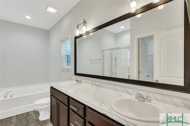 full bathroom featuring hardwood / wood-style floors, vanity, toilet, and plus walk in shower