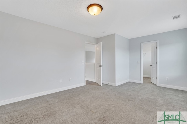 unfurnished bedroom featuring light colored carpet and a closet