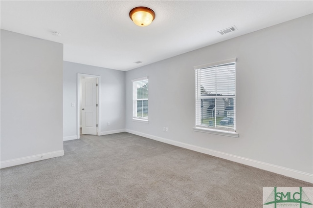 spare room featuring light colored carpet