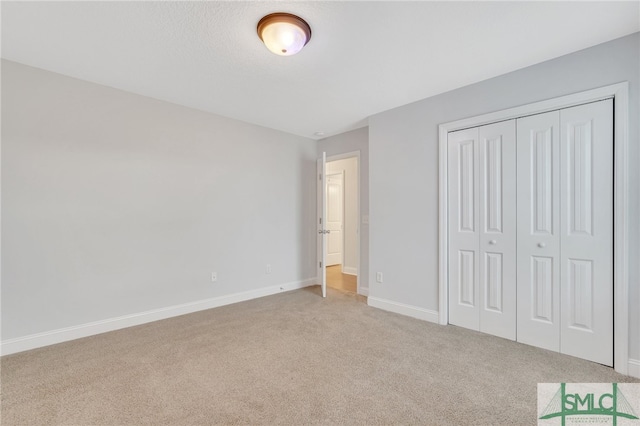 unfurnished bedroom featuring light colored carpet and a closet