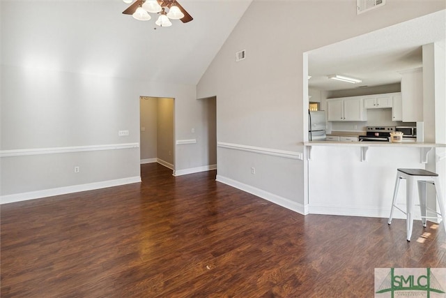 unfurnished living room featuring ceiling fan, dark hardwood / wood-style flooring, and high vaulted ceiling