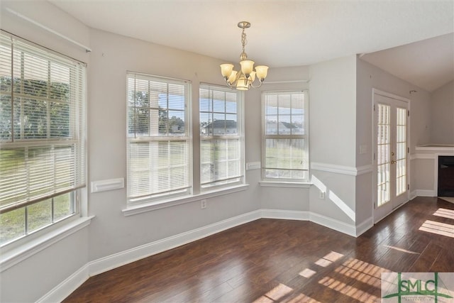 unfurnished dining area with a chandelier, french doors, and dark hardwood / wood-style flooring