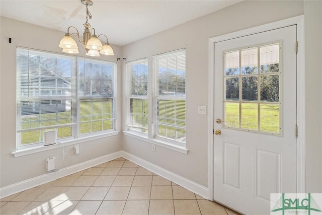 doorway to outside with light tile patterned floors, a healthy amount of sunlight, and a notable chandelier