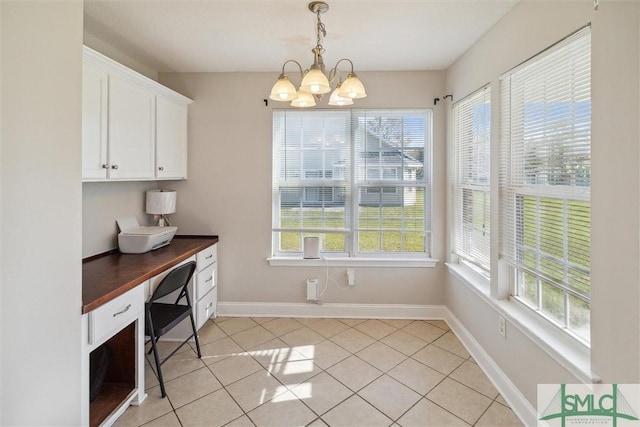 dining space with light tile patterned floors, a healthy amount of sunlight, and a notable chandelier