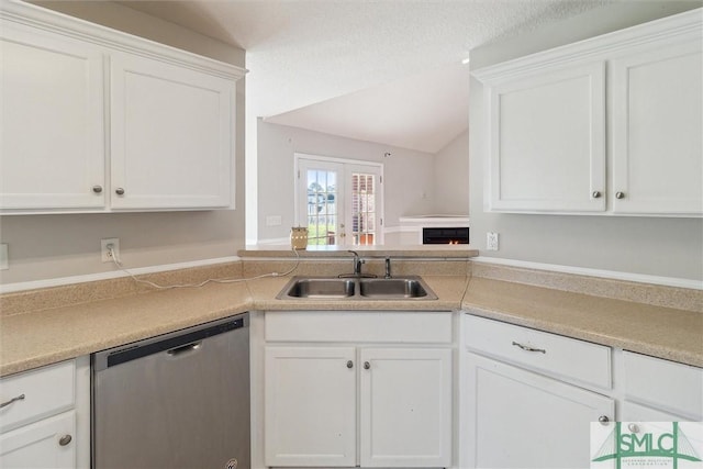 kitchen featuring sink, french doors, stainless steel dishwasher, vaulted ceiling, and white cabinets