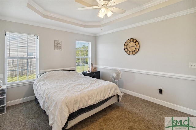 bedroom with a raised ceiling, ceiling fan, crown molding, and dark carpet