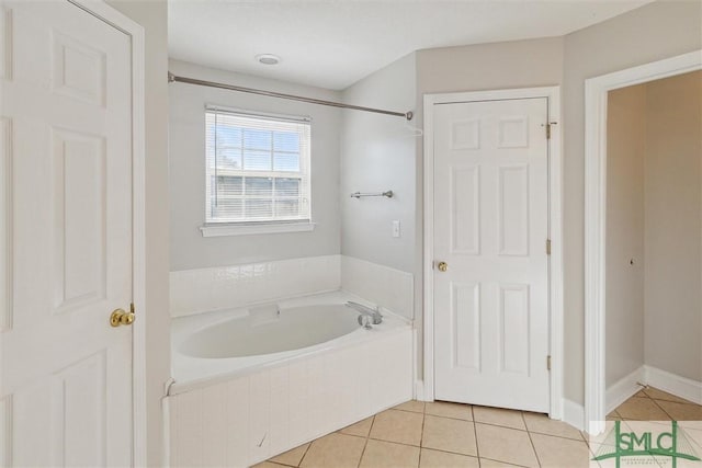 bathroom featuring tile patterned flooring and a relaxing tiled tub