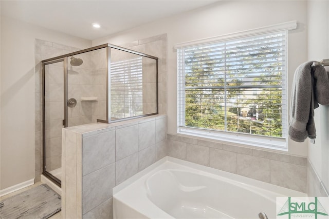 bathroom featuring shower with separate bathtub