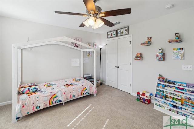 carpeted bedroom featuring ceiling fan and a closet