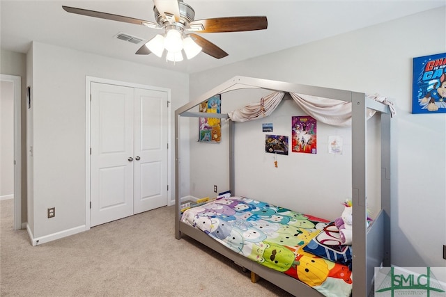 carpeted bedroom with ceiling fan and a closet