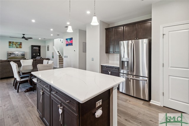 kitchen with stainless steel fridge, light hardwood / wood-style floors, a kitchen island, and pendant lighting