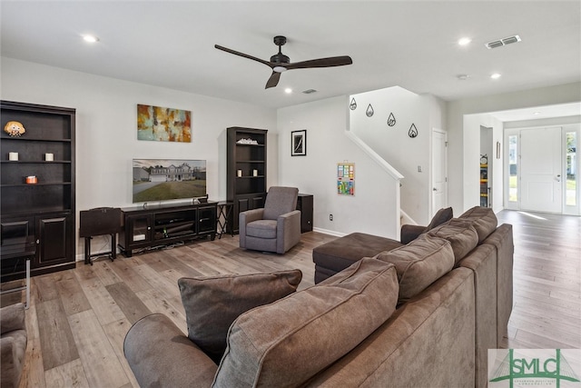 living room with light wood-type flooring and ceiling fan