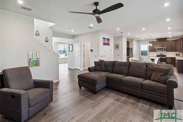 living room featuring ceiling fan and light wood-type flooring