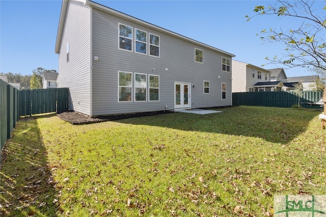 back of house with a yard and french doors