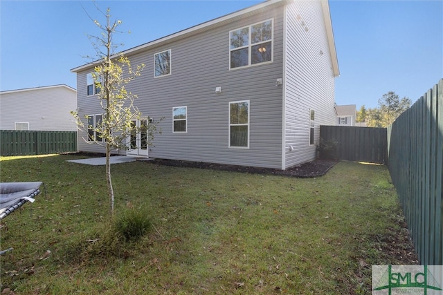 rear view of property with a lawn and a patio area