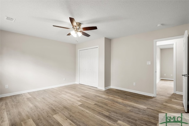 unfurnished room featuring ceiling fan, wood-type flooring, and a textured ceiling