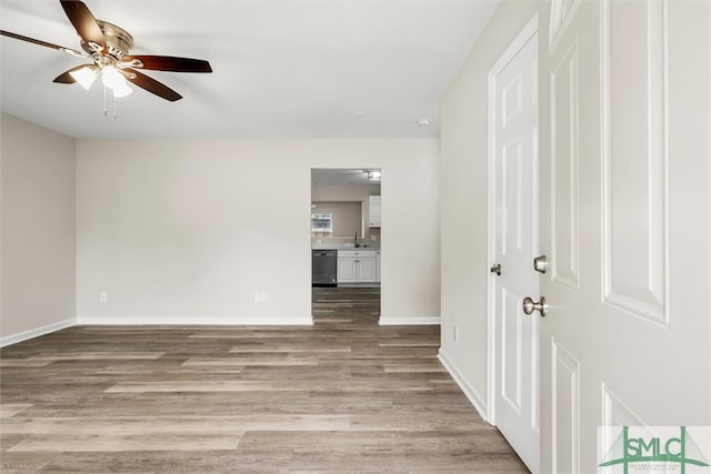 unfurnished room with hardwood / wood-style flooring, ceiling fan, and sink