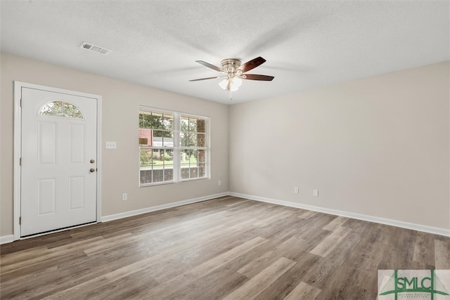 entrance foyer with a textured ceiling, light wood-type flooring, and ceiling fan