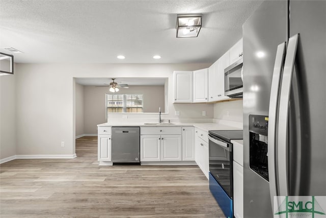 kitchen with white cabinets, sink, light wood-type flooring, and stainless steel appliances