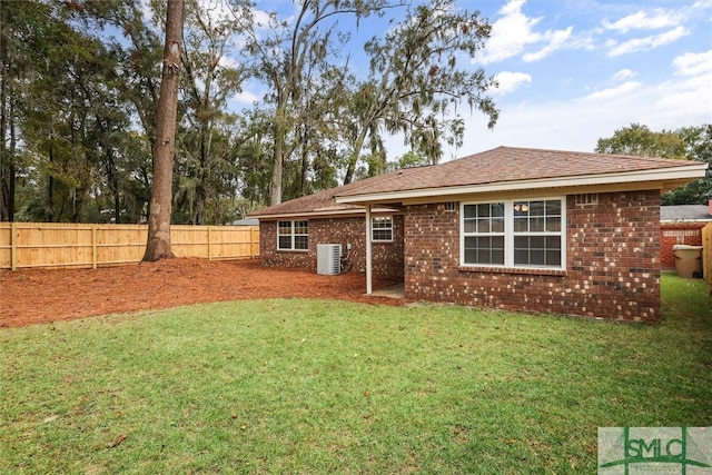 rear view of house featuring a yard and central AC unit