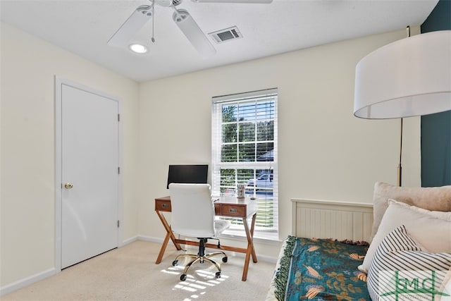 carpeted office space featuring ceiling fan