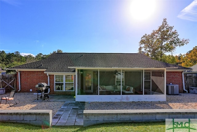 rear view of property with central air condition unit, a patio area, and a sunroom