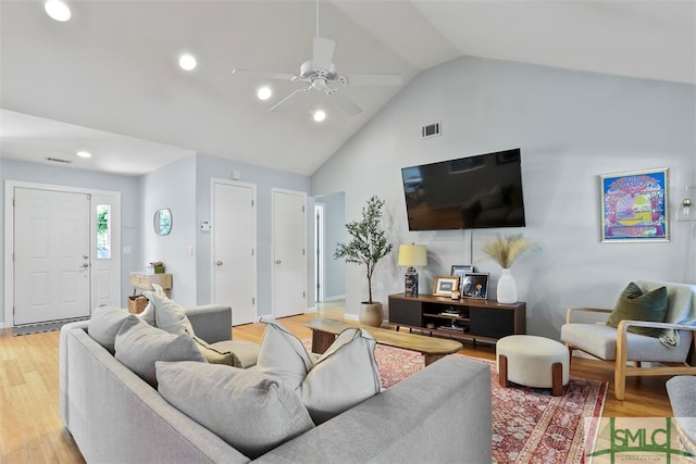 living room featuring ceiling fan, light hardwood / wood-style flooring, and lofted ceiling